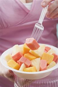 Woman eating exotic fruit salad