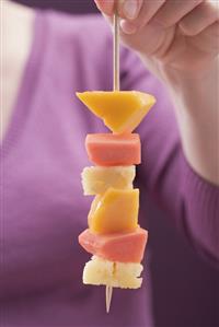 Woman holding exotic fruit skewer