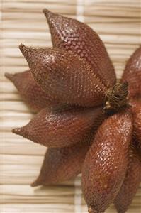 Several salak fruits on straw mat (close-up)