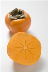 Whole persimmon and half a persimmon