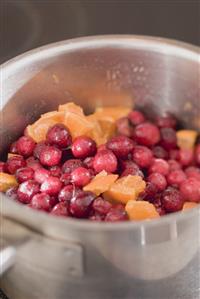 Making cranberry sauce: cranberries and oranges in pan