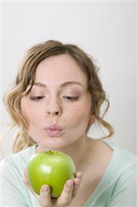 Woman holding green apple