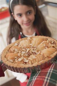 Hands holding apple tart, girl in background