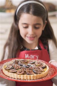 Girl holding freshly-baked fig tart