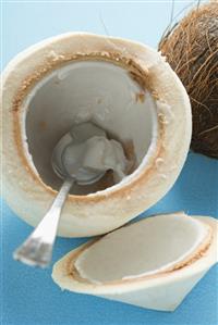 Coconut, shelled and hollowed out, with spoon