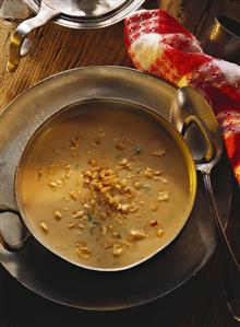 Peanut soup with celery in brass bowl