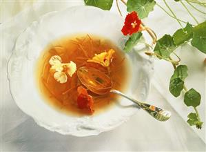 Vegetable stock with julienne carrots & nasturtium flowers