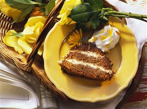 Piece of filled chocolate cake (Rehrücken) on plate with cream