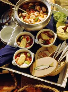 Fancy Bouillabaisse: French Fish Soup in Tureen and in Bowls with white Bread Slices coated with Garlic Mayonnaise on Tray