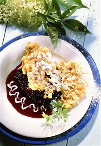 Fried elderberry fritters with blueberry sauce on plate