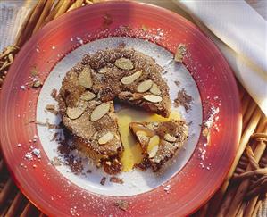 Small chocolate tart with almonds and orange sauce