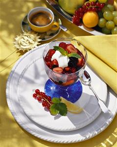 Assorted berry gelatin with cream in a dessert glass