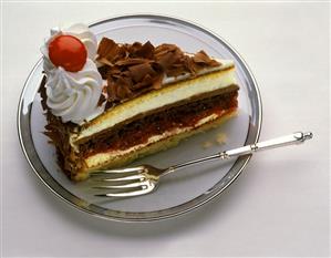 A piece of Black Forest cherry gateau on cake plate