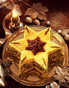 Star-shaped cake with icing, chocolate sprinkles & pistachios