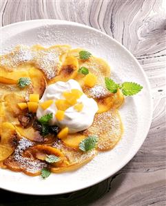 Flambéed peach omelette with cream yoghurt and peaches