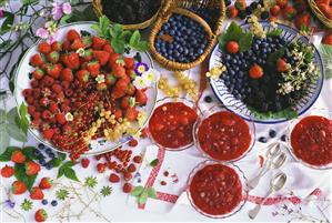 A few bowls of red berry cream & many fresh berries on table