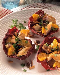 Poultry & orange salad with raisins, pine nuts in radicchio