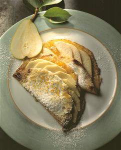 Two crepes with pears, icing sugar & honey on plate