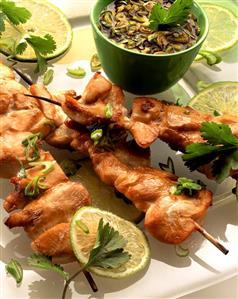 Chicken kebabs, lime slices, and bowl of marinade (1)