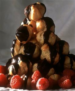 Pyramid of profiteroles with chocolate icing & raspberries