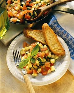 Tomato and courgette ragout on plate with baguette slices