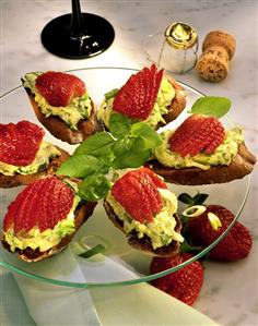 Snacks with avocado puree & strawberries on glass plate