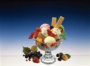 Ice cream sundae with fresh fruit, berries, cream & wafers