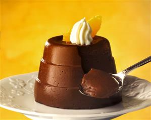 Turned-out chocolate blancmange, decorated with cream & orange