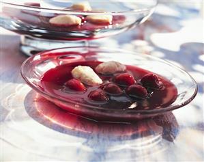 Cold cherry soup with semolina dumplings on glass plate