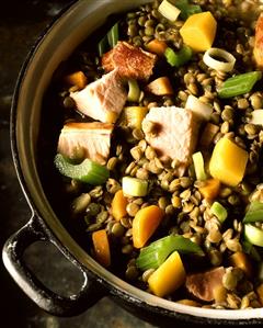 Lentil stew with pork neck, carrots and celery in pot