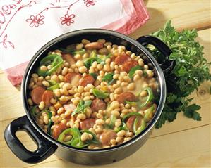 White bean stew with smoked sausage and leek in pot