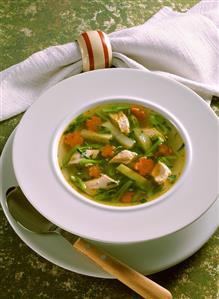 Vegetable soup with chicken in soup plate