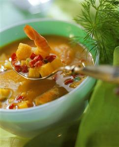 Fish soup with curry in bowl and on spoon (1)