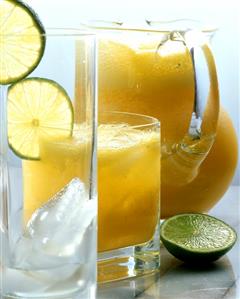 Mango and orange juice in glass jug and glass