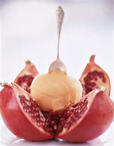 A scoop of apple ice cream on opened pomegranate