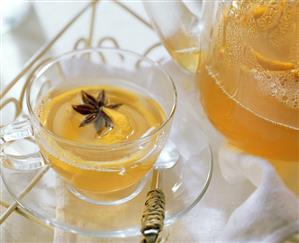 Lemon tea punch with star anise in glass cup