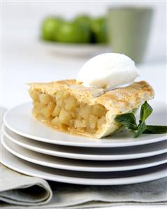 A piece of apple pie with a scoop of ice cream, on plates