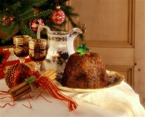 Christmas pudding, cinnamon sticks, wine glasses, carafe