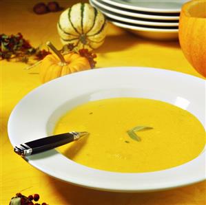 Pumpkin soup with sage on plate