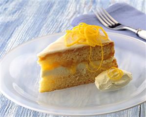 A piece of orange cake with orange cream & orange zest