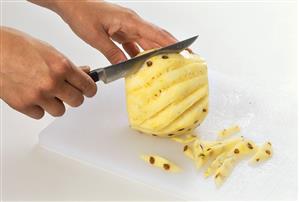 Cutting the eyes out of pineapple
