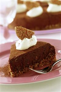 A piece of chocolate cake decorated with cream & amaretti