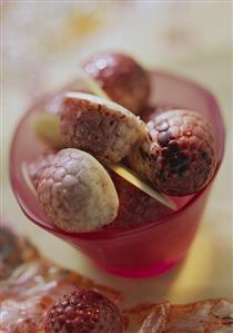 Filled raspberries chocolates in pink glass