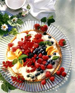 Colourful fruit gateau with orange cream on cake plate