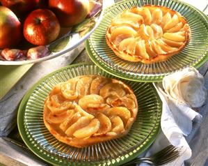 Two tartes tatins on glass plates