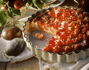 Plum and coconut tart in a china dish, decoration: plums