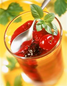 Red berry cream garnished with mint in glass