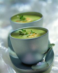 Pea soup with shrimps in two soup mugs