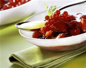 Red berry cream in bowl and custard on spoon