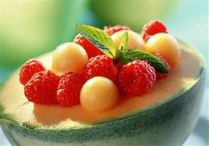 Melon balls and raspberries in half a honeydew melon